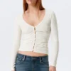 Belle B Strickjacke mit Rüschen und V-Ausschnitt – Weiß Belle B Strickjacke mit Rüschen und V-Ausschnitt – Weiß